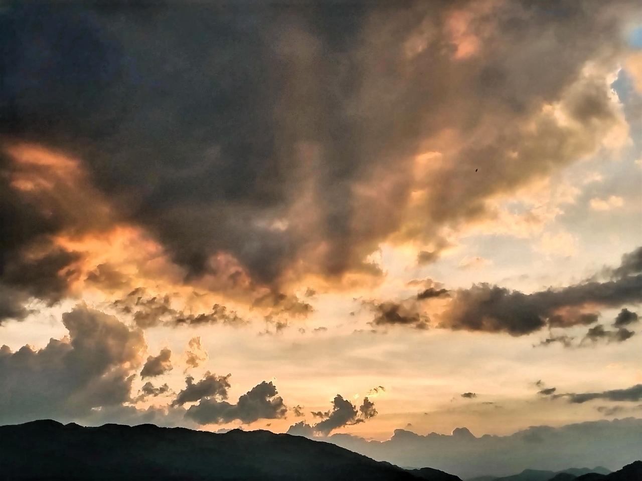 云海翻滚，夕阳西下，山峦起伏。