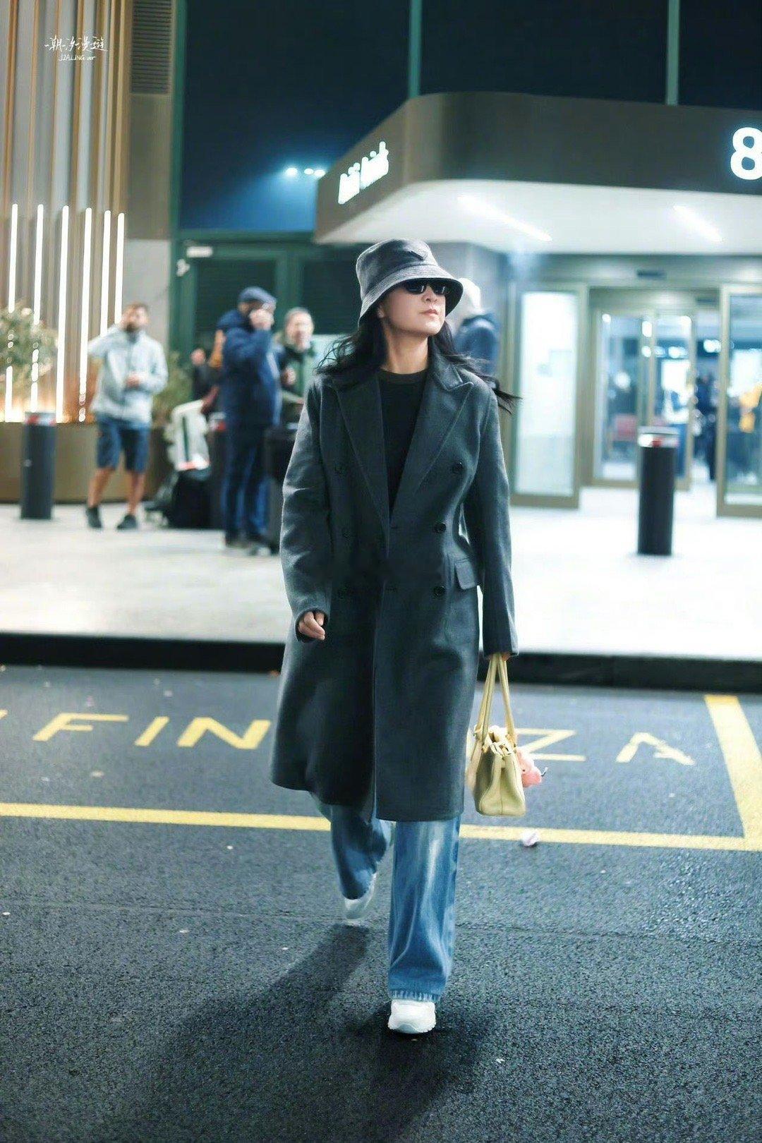 贾玲出发米兰时装周，以Prada品牌代言人身份，一身利落灰色大衣造型现身机场，启