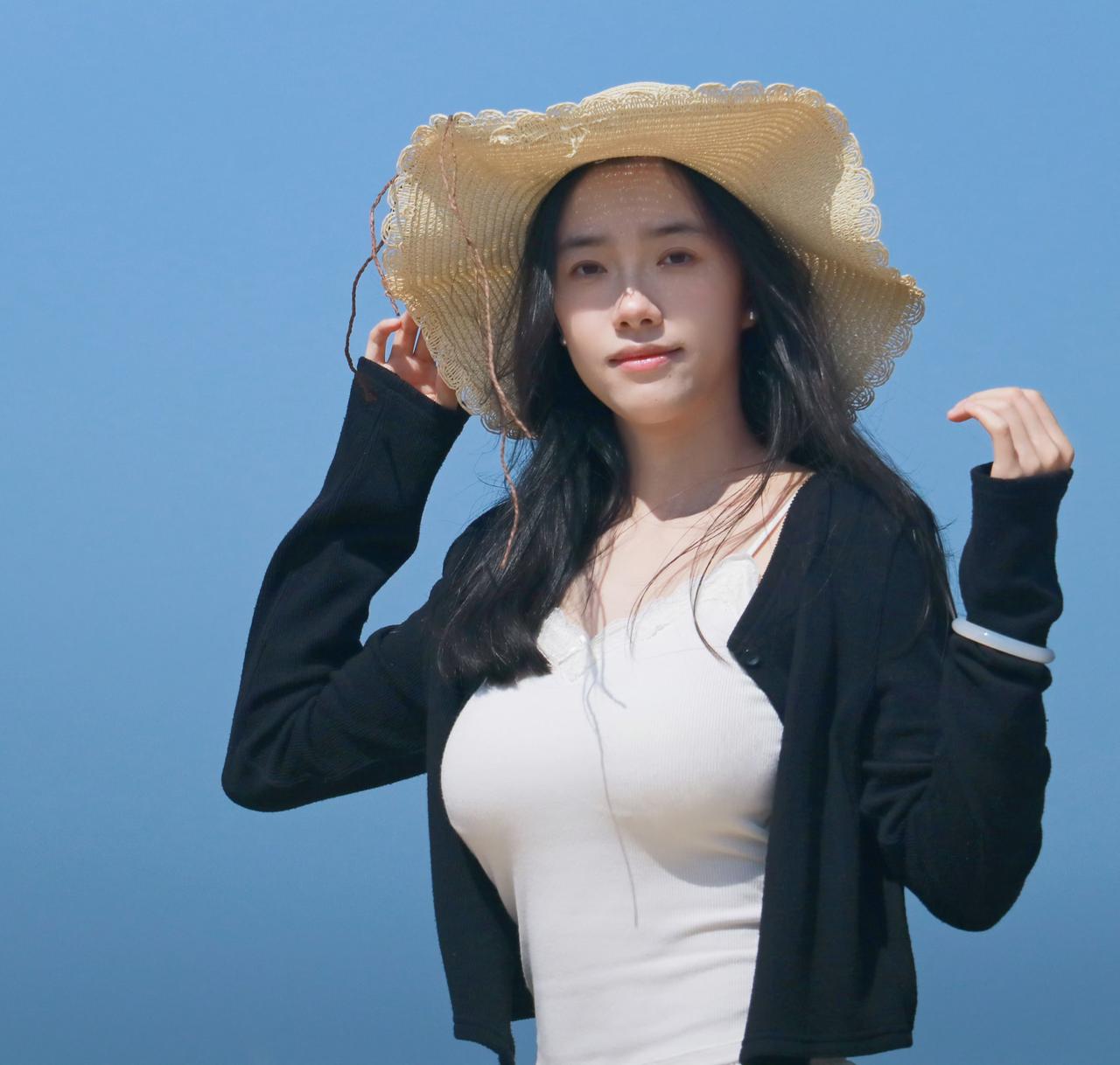 海风漫过发梢，蓝天与大海铺成干净底色，远处风车缓缓转动。一顶草帽，一身温柔穿