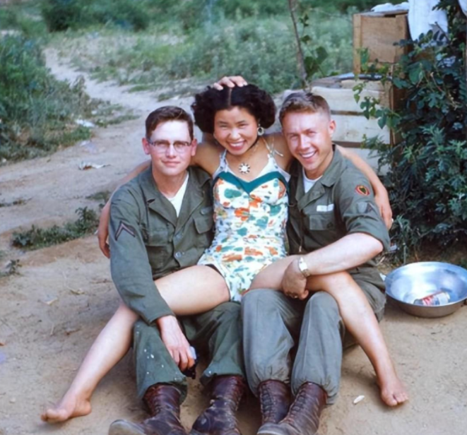 1947年，1韩国女子坐在两位美国大兵的腿上，摆出了一个十分豪放的姿势，乍一看，