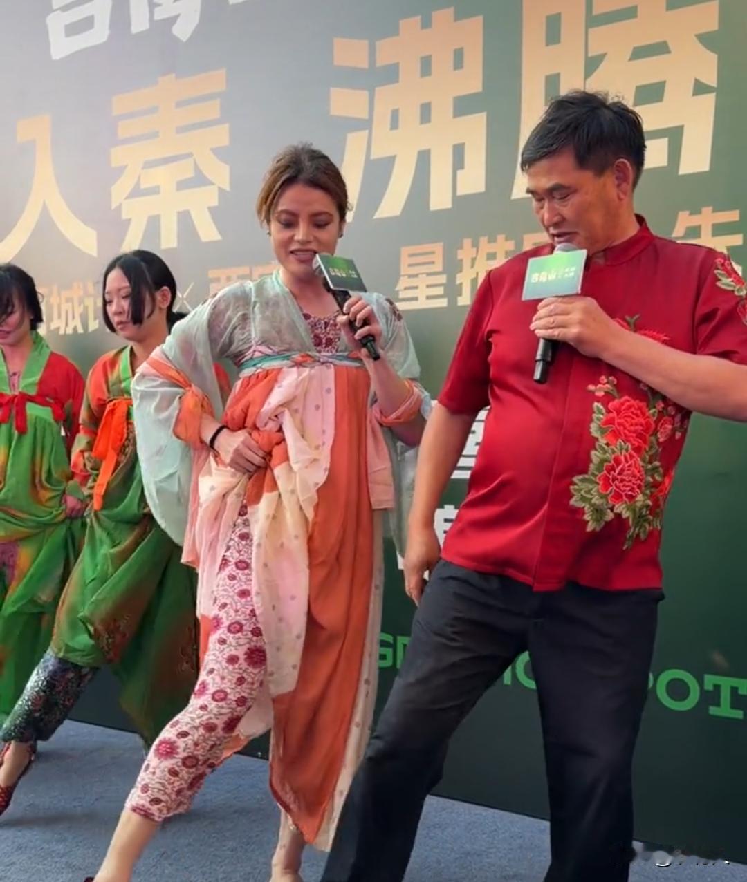 朱之文身穿红牡丹短袖，跟着外籍女主持一起压腿、摆动作排练走位。现在朱之文是真有魅