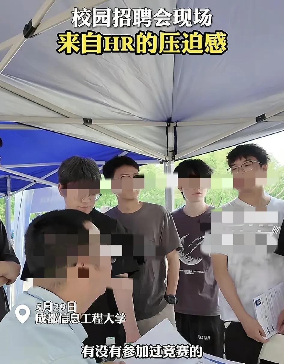 5月29日，成都信息工程大学招聘会现场，几名毕业生同时在一家招聘企业摊位前递简历