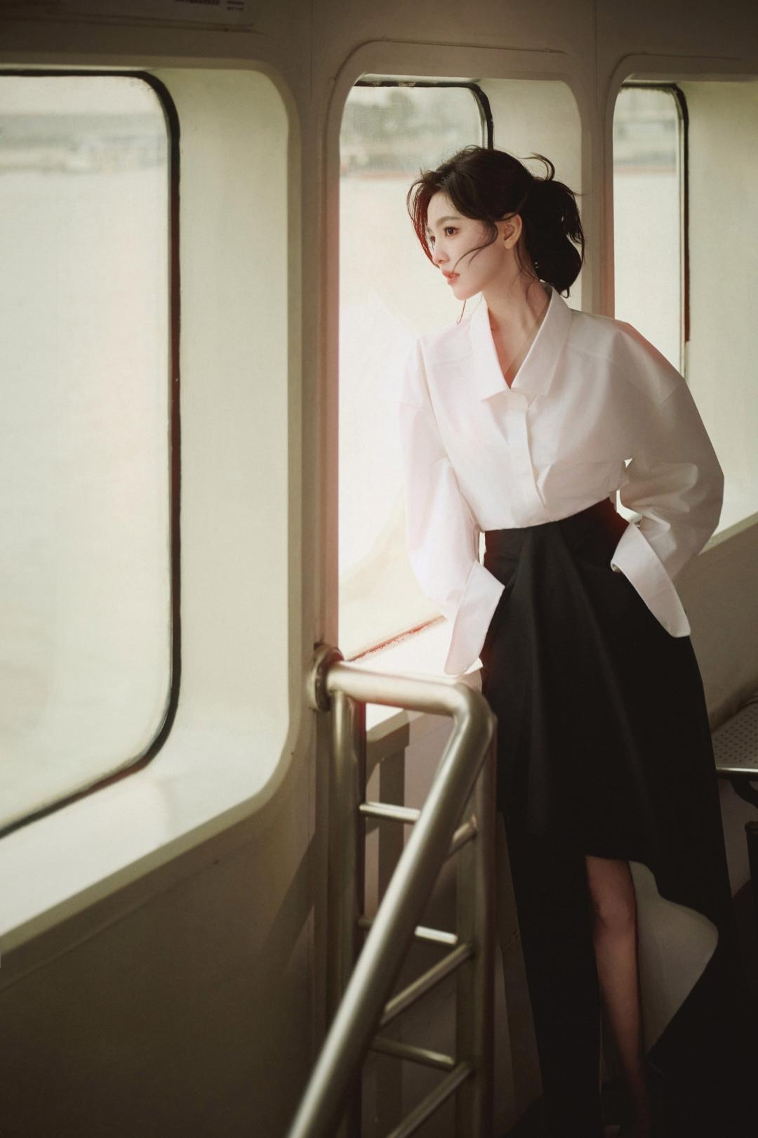 江风穿堂，轮渡轻摇，章若楠置身于江轮的光影褶皱里，用一身经典的黑白穿搭，把一段寻