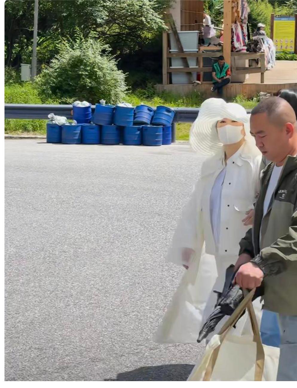 72岁的林青霞在九寨沟度假被偶遇，她穿着白色外套和白色长裤，戴着白色遮阳帽，造型