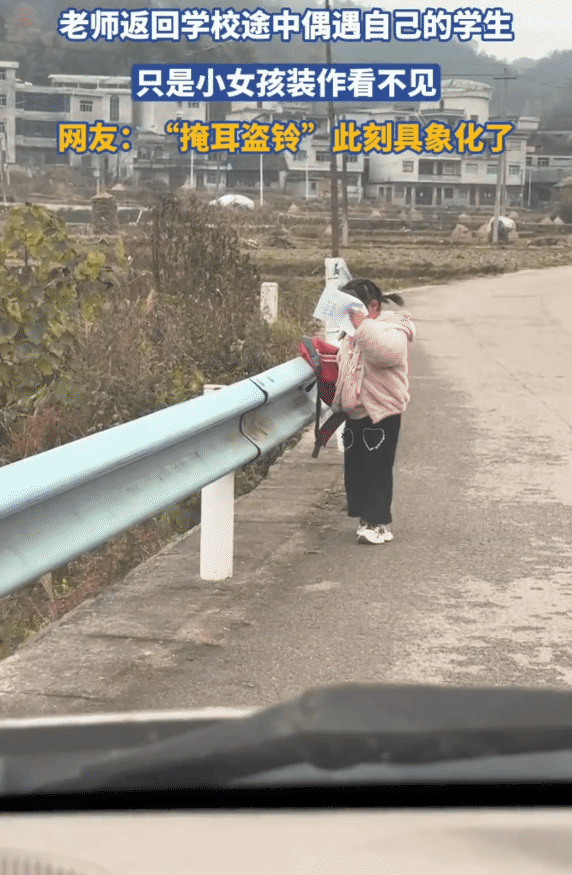 “你看不见我！”小女孩在路上偶遇返回学校的老师。突然，她用作业本挡住自己的脸，装