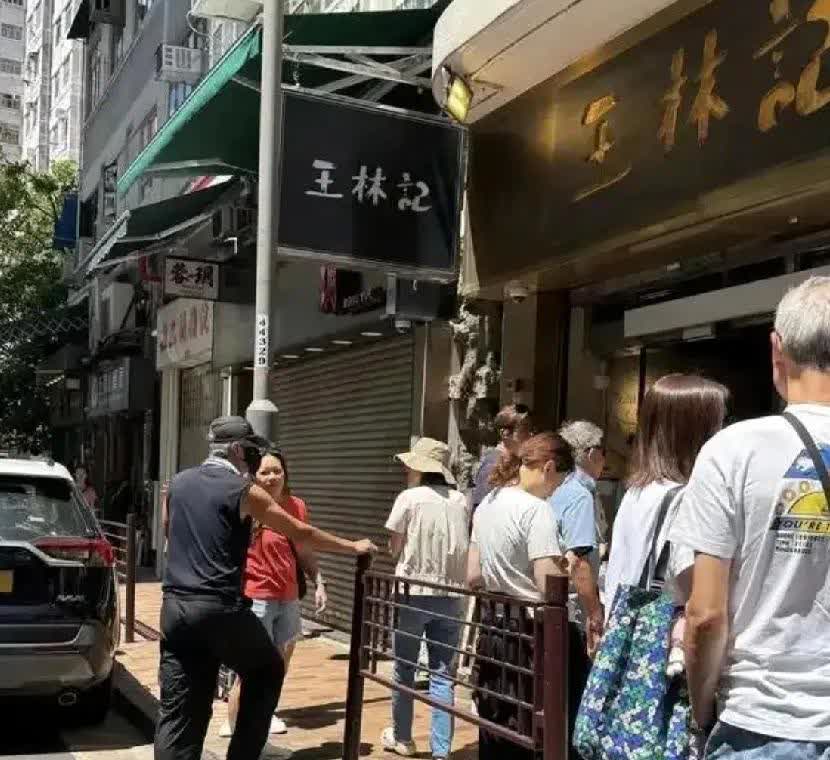 70岁的周润发开着豪车出现在香港筲箕湾小吃街，面馆排队吃面。他穿着无袖T恤配工装