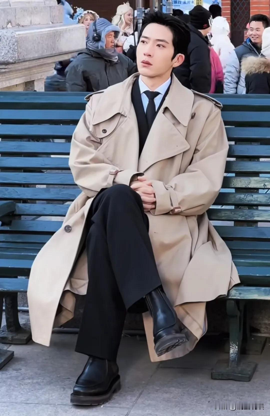 井柏然现身哈尔滨拍戏，穿着一件米黄色风衣，内配西装，脚踩短靴，个子高挑，身材清瘦