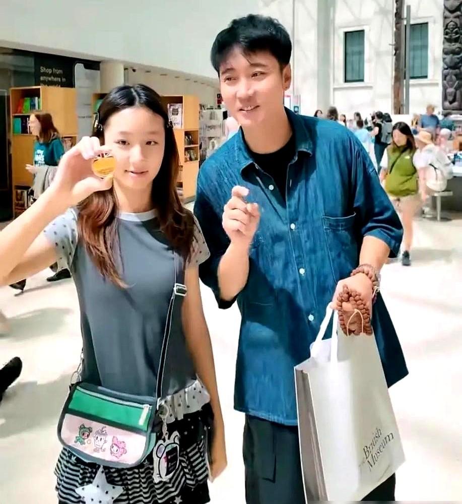还真有两把刷子，张丹峰又把洪欣拉出来了。一家三口，英国街头，他揽着洪欣的肩，
