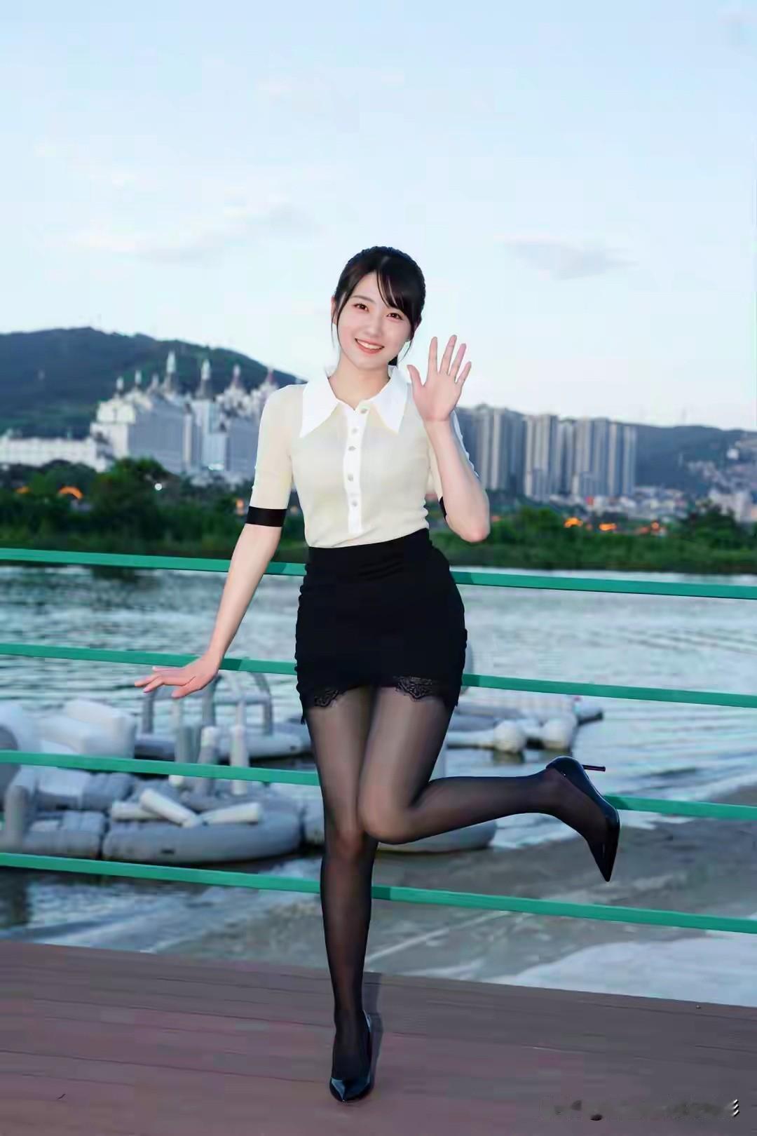 白衫黑裙映江明，雪肤含笑步轻盈。手挽小包风拂袂，栈桥留影水云清。