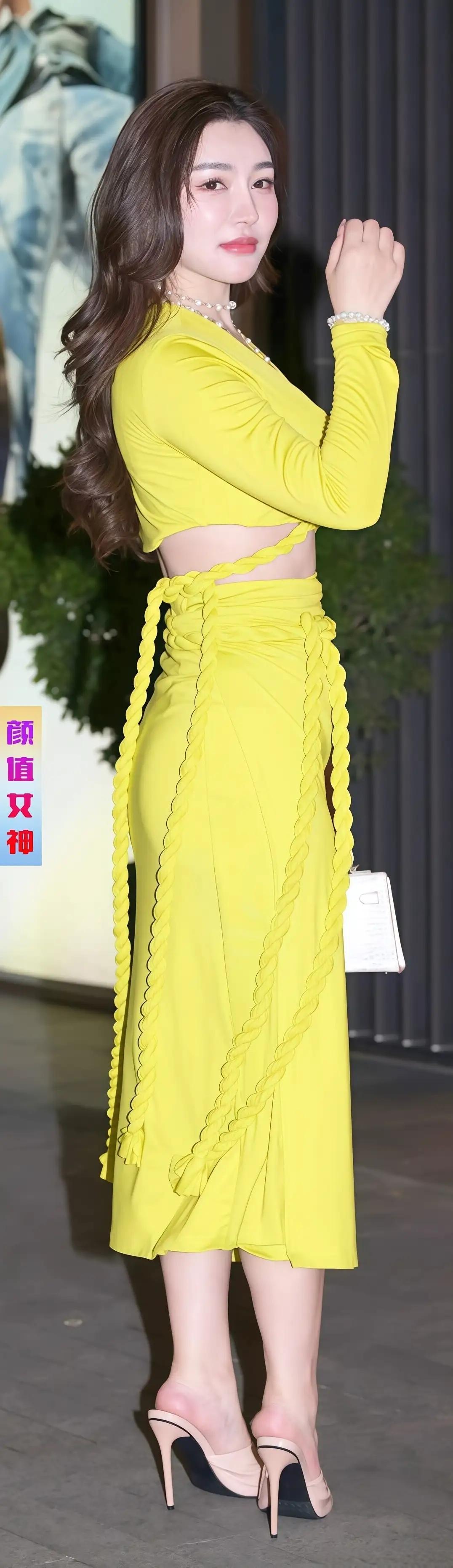 明艳黄衣，绽放街头时尚魅力在繁华都市的街头，一位女子以一袭亮眼的黄色套装成为