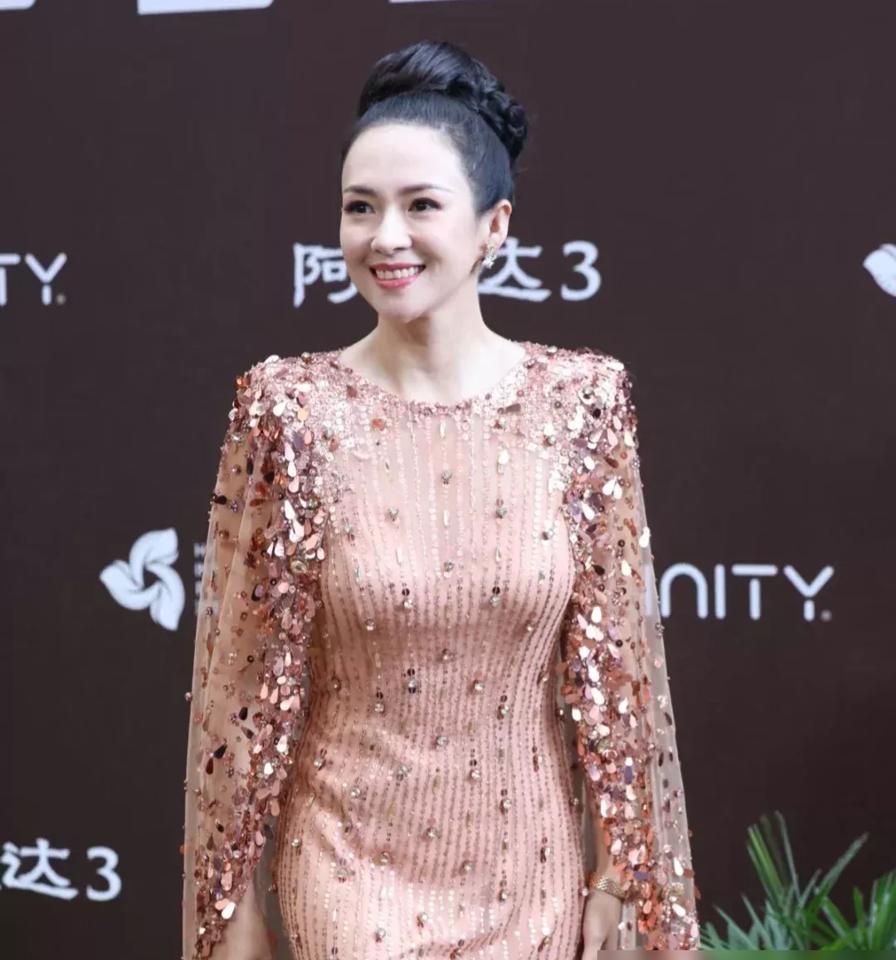 三亚首映礼的聚光灯扫过来。橙色亮片裙闪得像海边的落日。46岁的章子怡，眼神亮