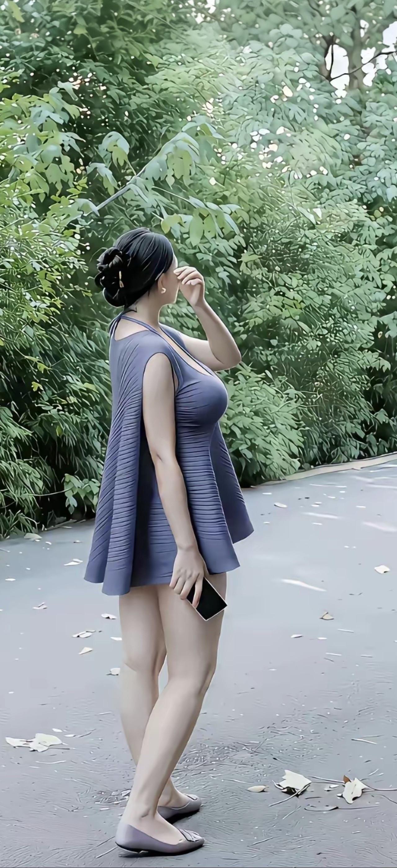 一个穿裙子的女士在公园里散步。