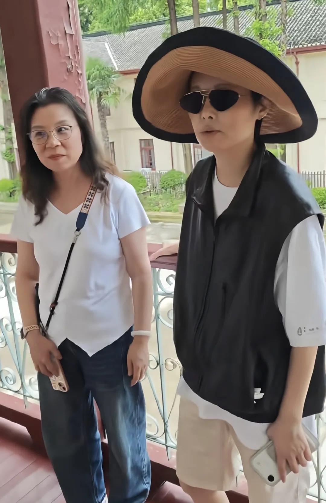袁立经过治疗终于出院了，老公梁太平推着她，她坐在轮椅上像粉丝招手，从远处看状态还