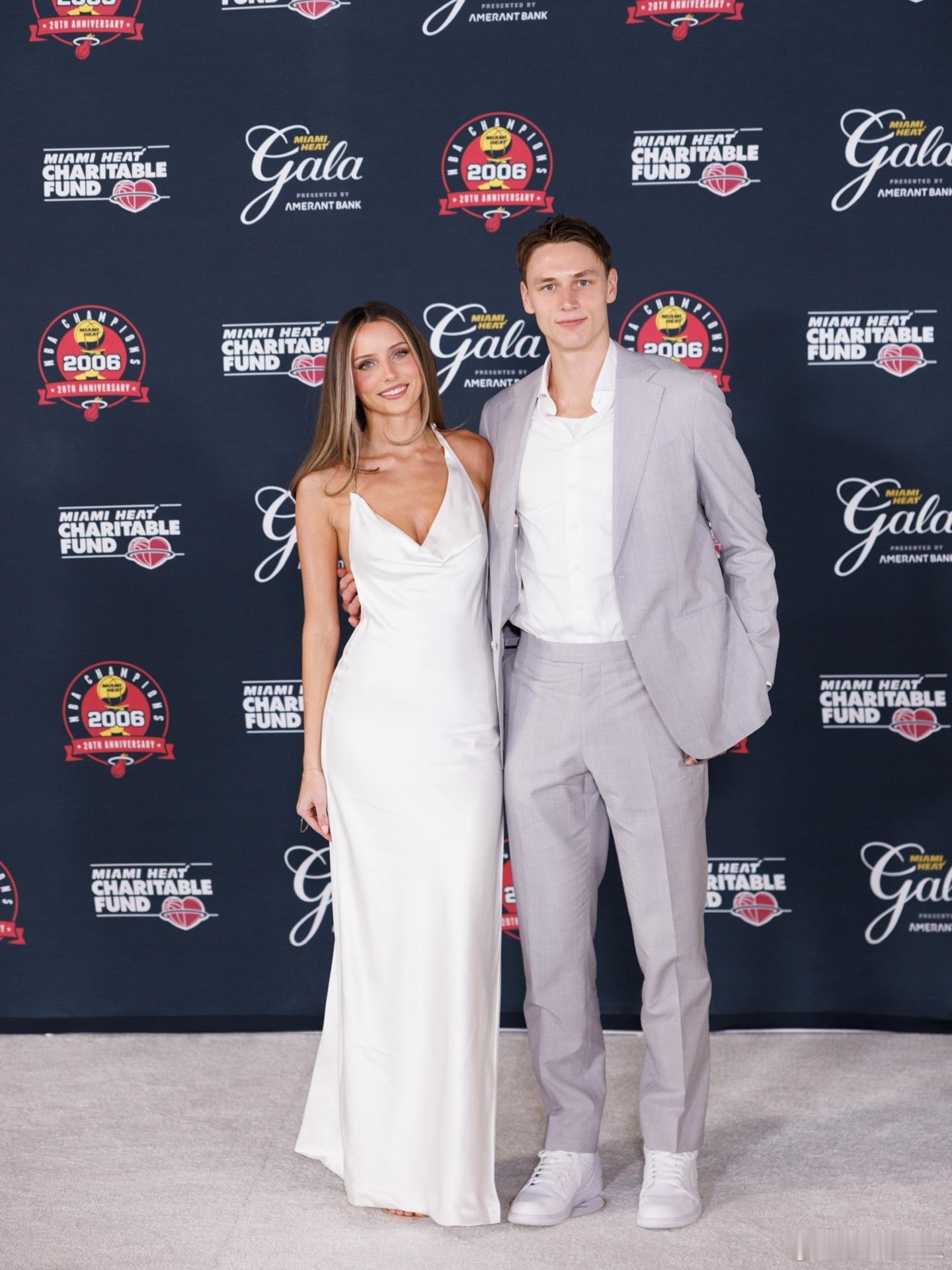 男才女貌，拉尔松和女友一起打卡热火更衣室！拉尔松一身浅灰西装＋白球鞋，干净清爽的