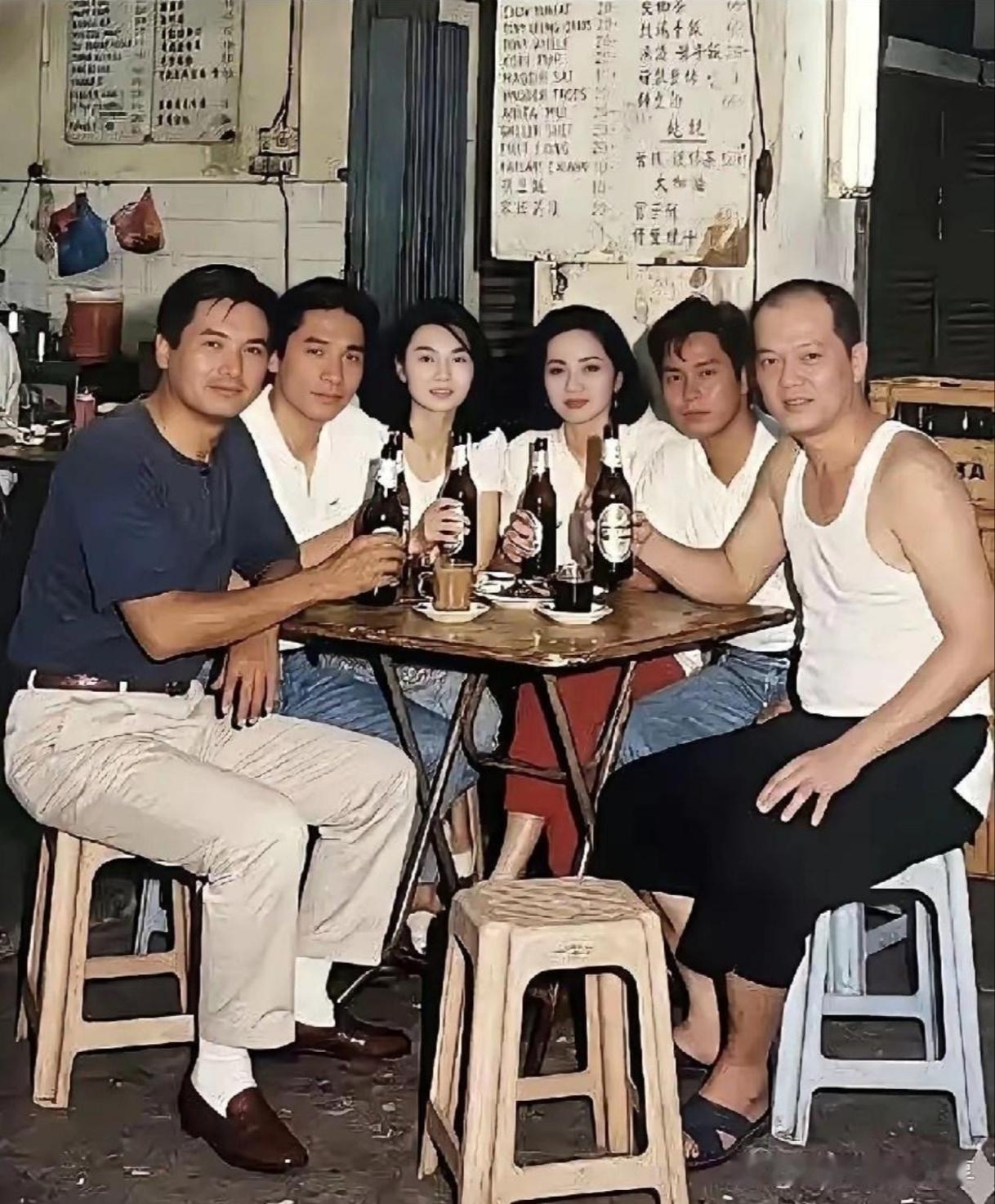 这张照片里除了周润发，还能认出几位熟悉的面孔。左二穿白衬衫的是梁朝伟，中间两位女