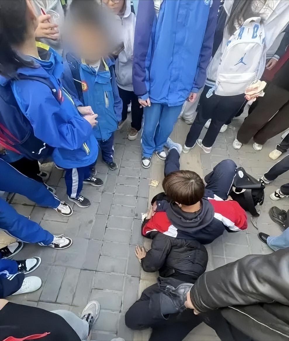 一个高中学生，死死用膝盖顶住一个一米八的中年男人。男人趴在地上动弹不得，嘴里还骂