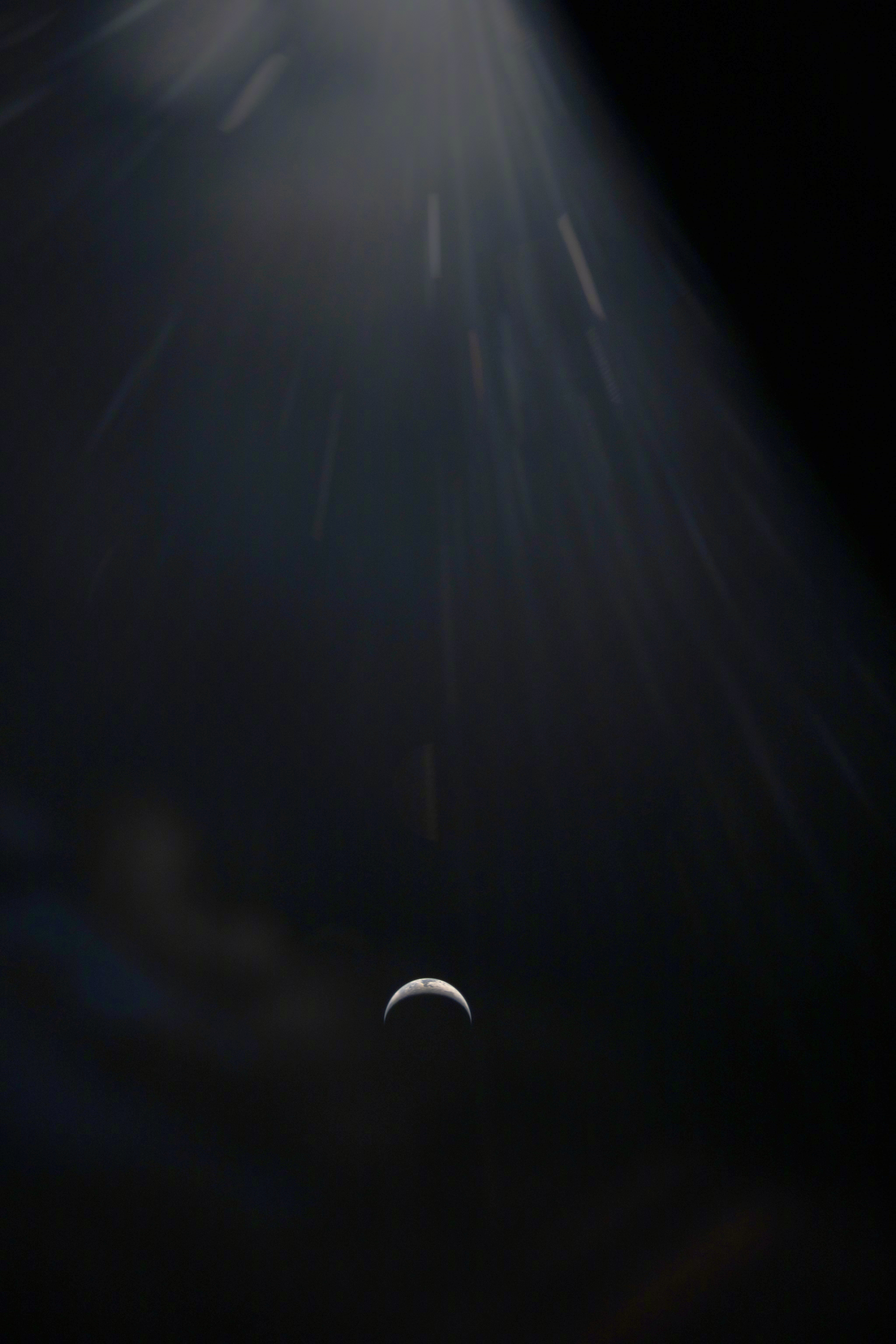 再来一张阿尔忒弥斯2号飞向月球途中拍摄的照片。那一弯“月牙”，其实是我们的地球。