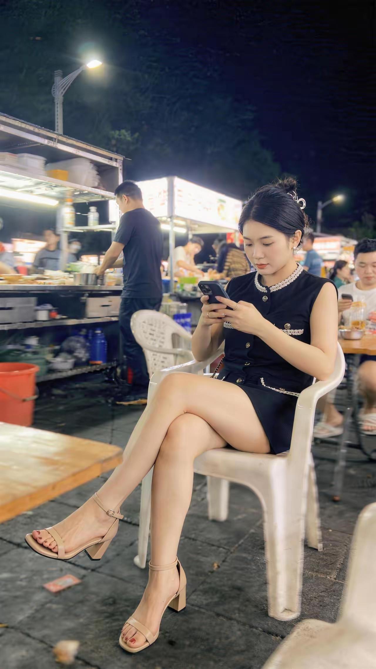 路边摊刷手机的女子。应该是原图吧，很有生活气息！