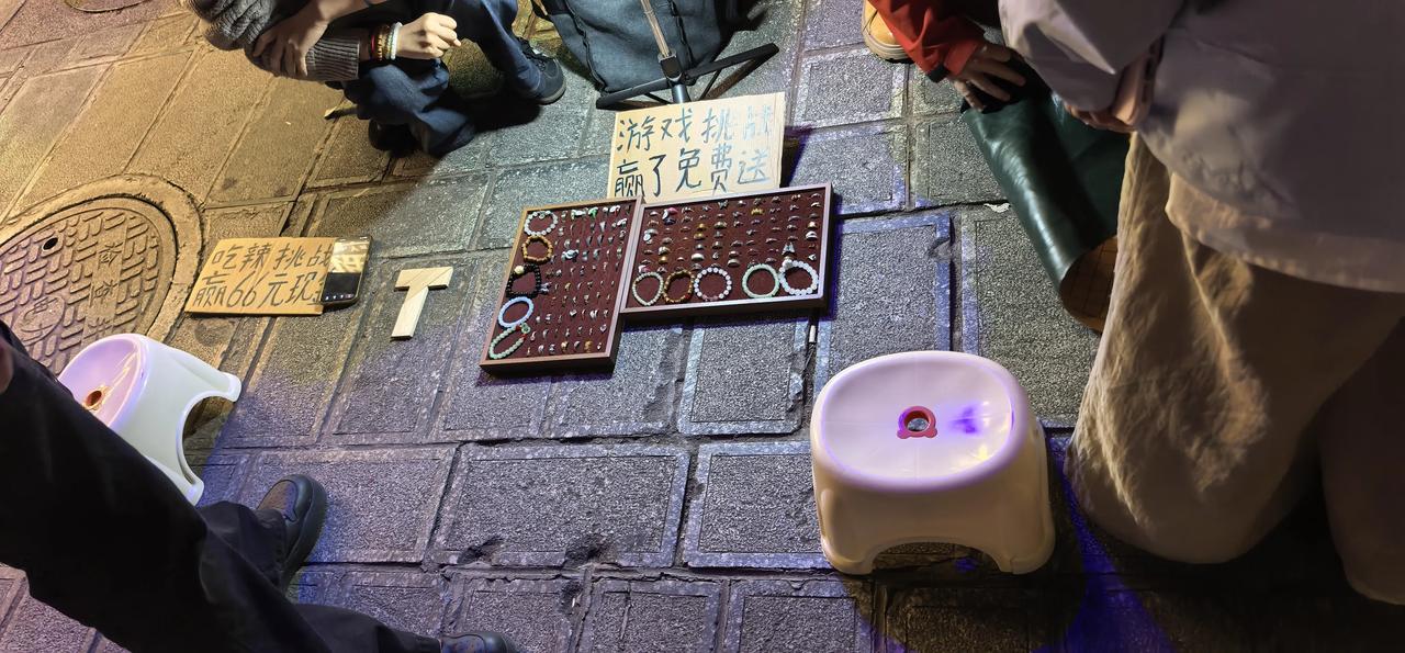 昨晚逛夜市，发现年轻人一个新的促销方式，玩游戏对赌卖东西。图中这个就是和摊主玩五