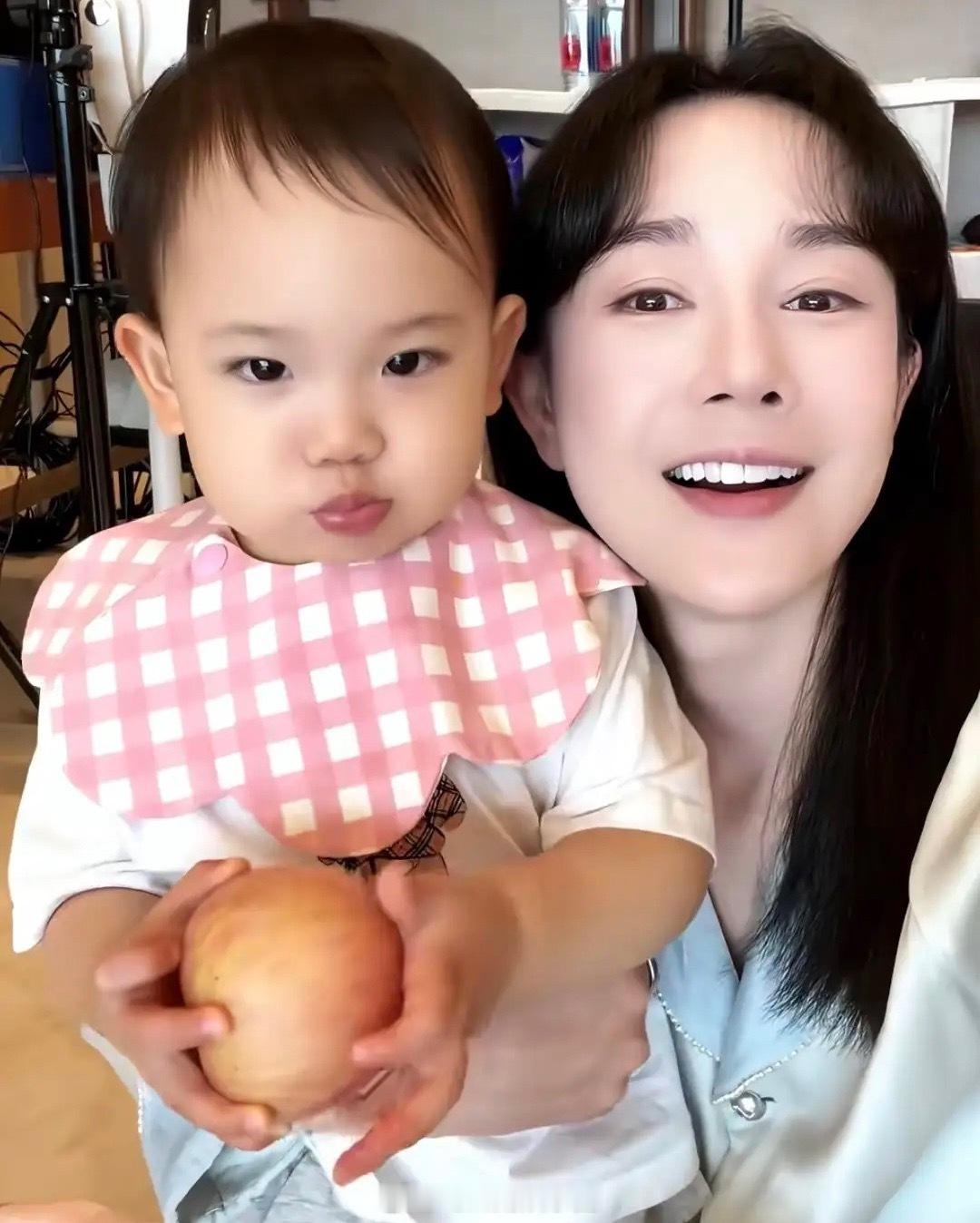张檬晒儿子吃饭萌照，Dylan戴着口水兜，手里捧着苹果好可爱，小家伙遗传爸爸长腿
