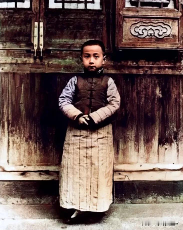 1918年，一位7岁的小男孩站在家门口的留影老照片，照片中的他穿着精致的小衣服，