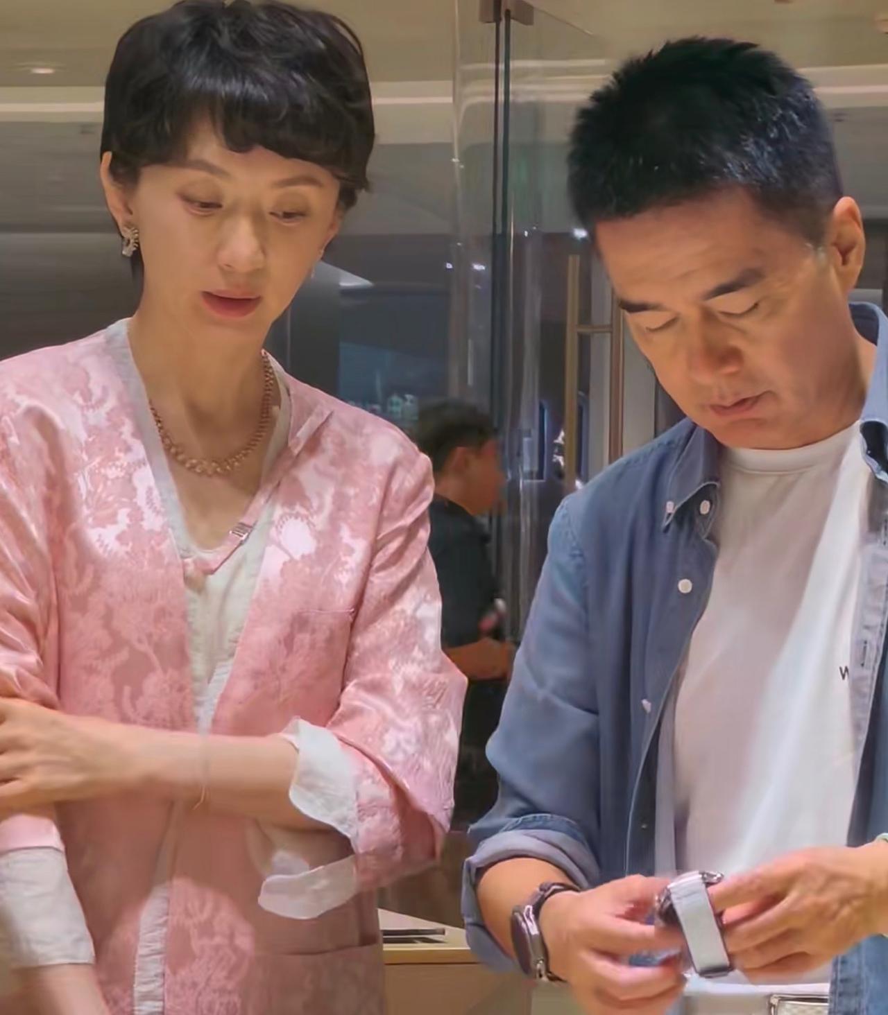 62岁许亚军与老婆现身手机店，一起试戴手表选新款手机，49岁张澍穿粉衣状态好，一
