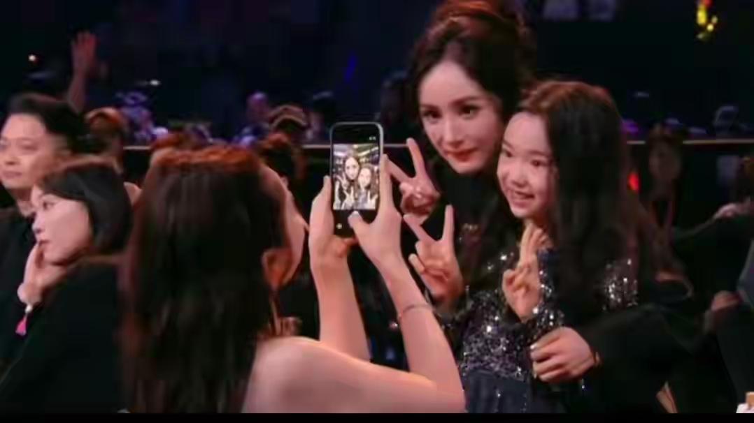 尖叫之夜内场星光熠熠，杨幂入场后却径直走向观众席，弯腰、蹲身，给董璇9岁的女儿小