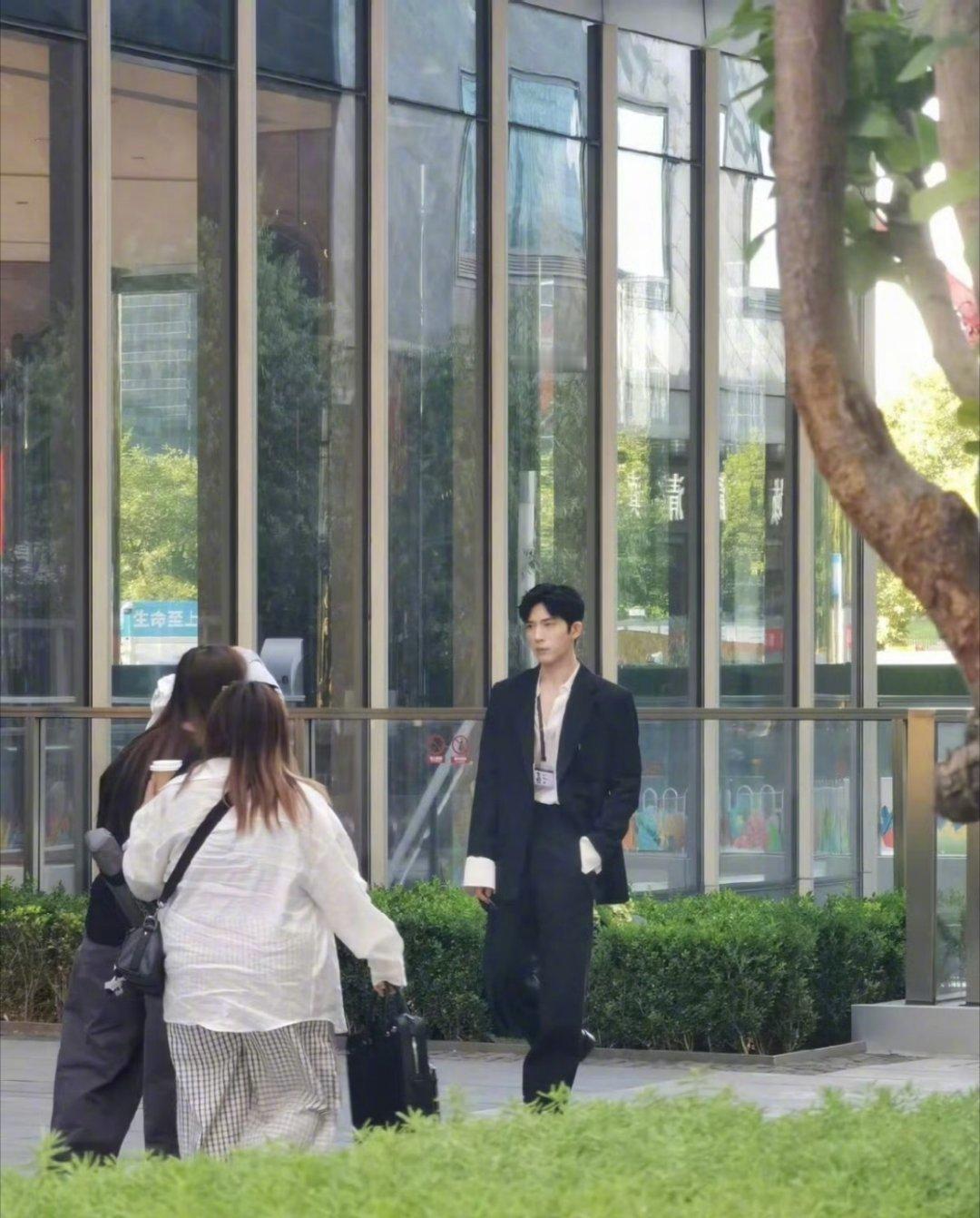 偶遇井柏然抱狗尾巴草拍摄偶遇井柏然国贸拍摄现场！领口大开搭配工牌，怀里还抱着一束