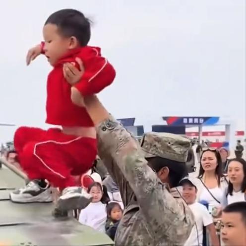 这下好了，要被全国人都羡慕了！吉林一个小男孩走到坦克战车前，踮起脚想爬上去可却只