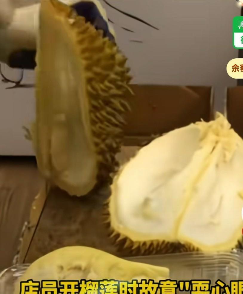 店员开榴莲时故意耍心眼，他把榴莲打开后，把榴莲肉取出来，把外壳扔到了旁边的箱