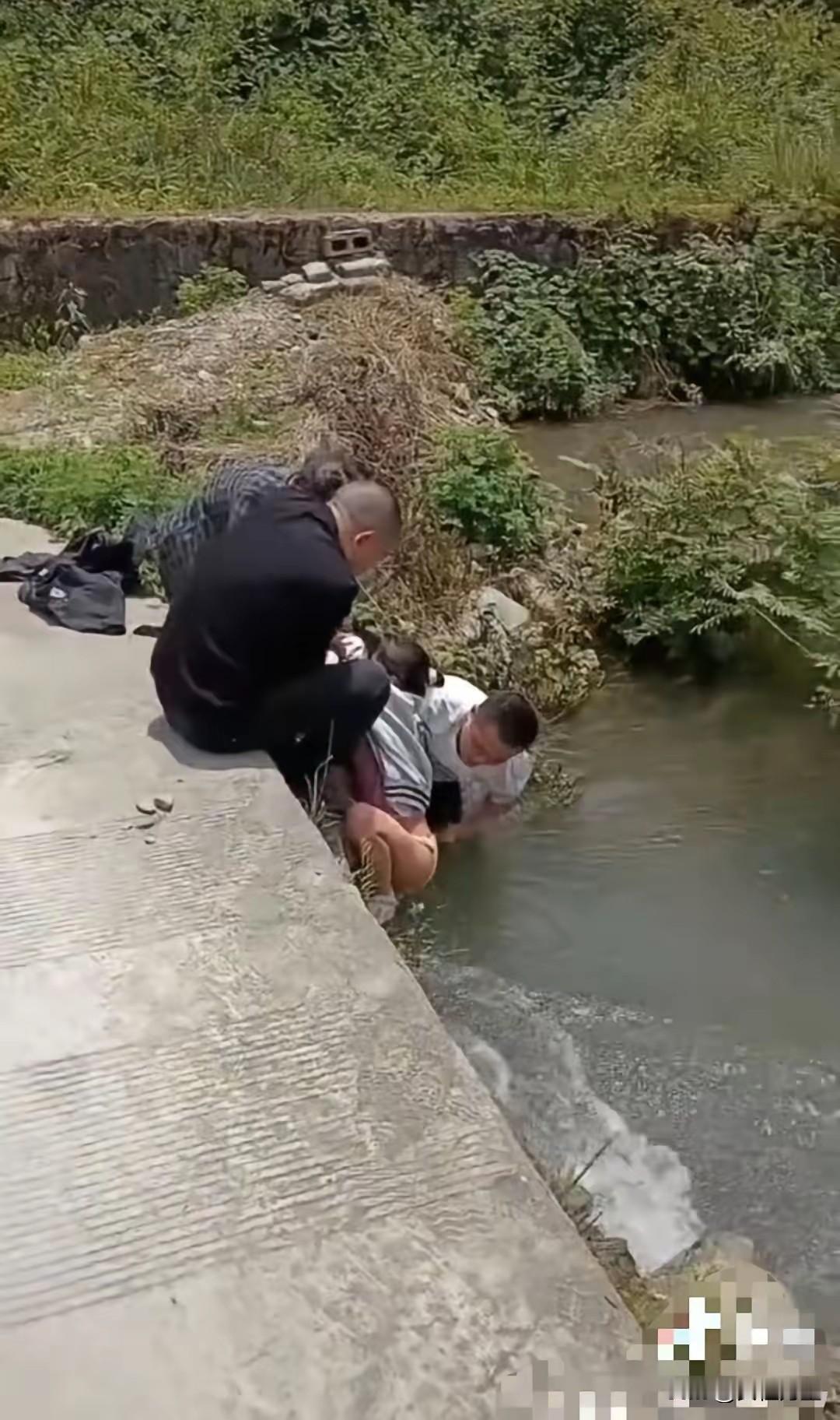 重庆女孩落水被卡桥洞，冲掉裤子和内裤，男子及时救起帮忙穿好，水中白衣男子下到河道