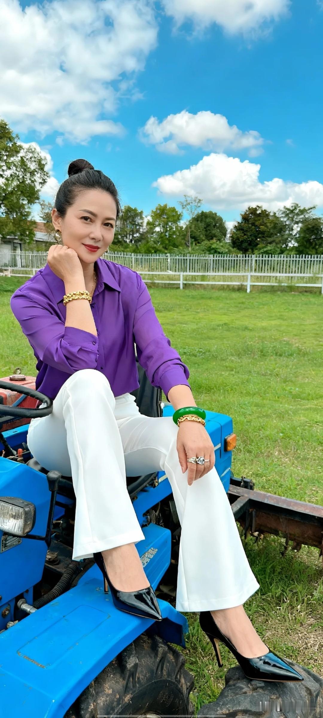 晒图笔记大赛户外场景，女子头发束起，身着紫色透视长袖衬衫，搭配白色喇叭裤与黑色尖