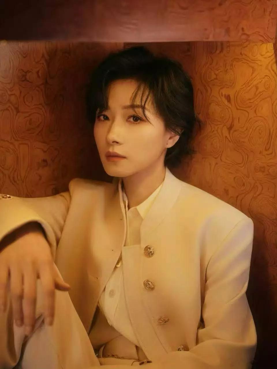 万茜目视镜头眼中充满故事感手拿羽毛侧脸线条优越