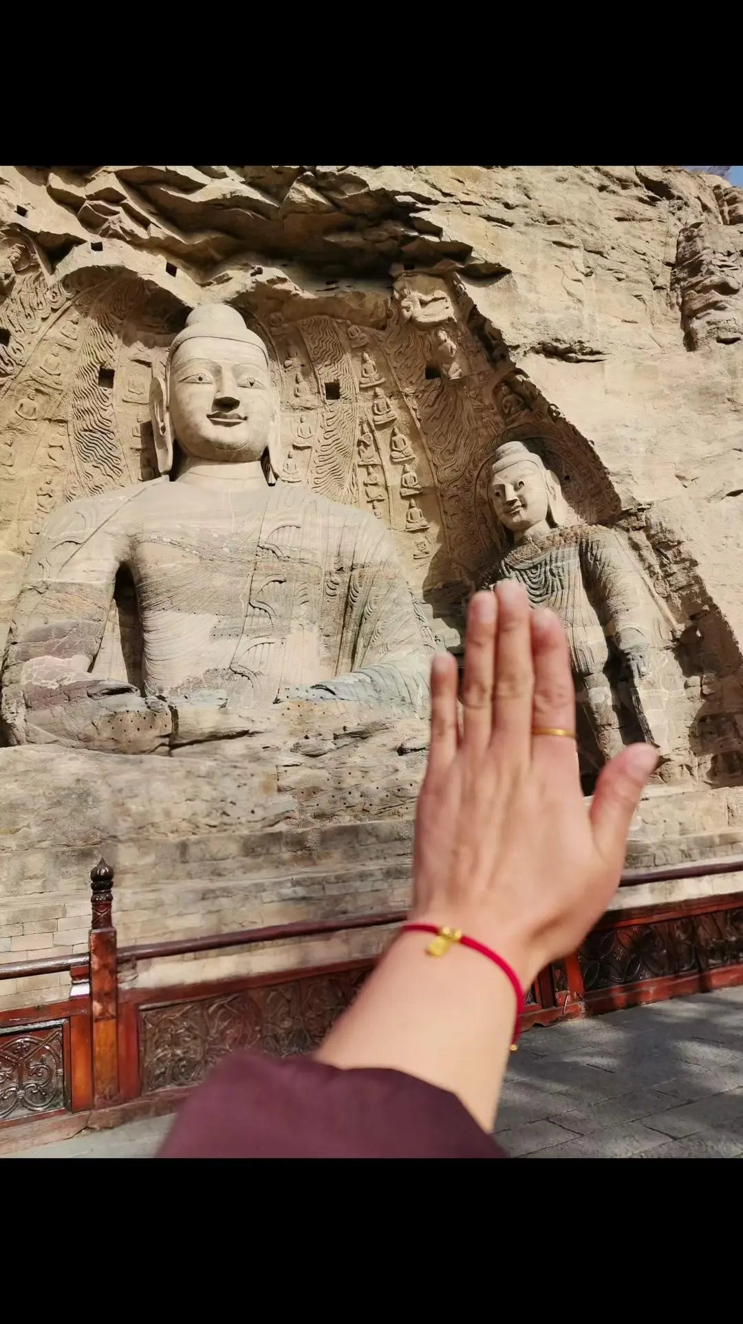 站在云冈石窟前，指尖掠过千年的石痕。阳光落在佛龛间，衣纹褶皱里藏着健陀罗的丝路风