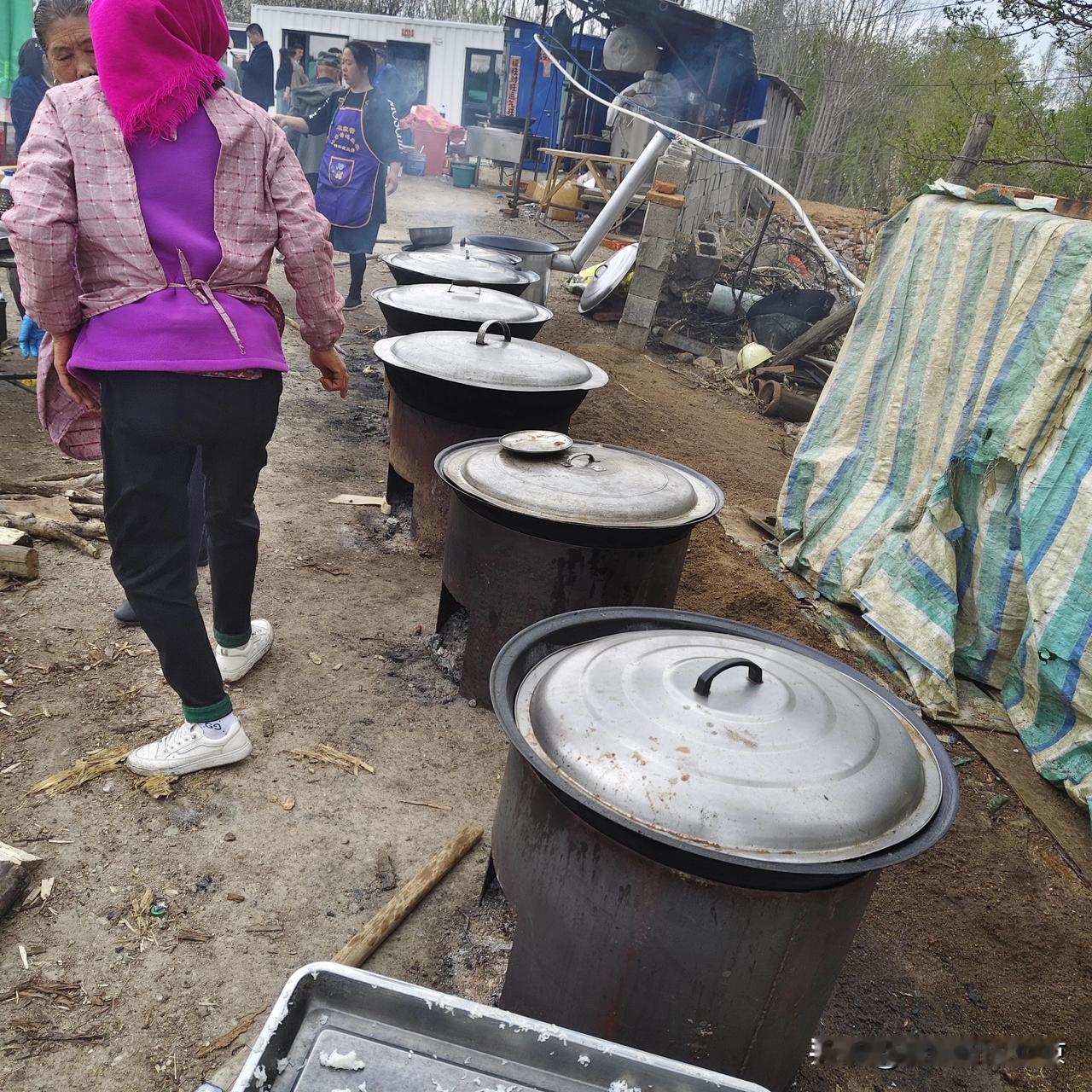农村大席在农村参加婚礼，开放式的一排大铁锅，煎炒烹炸，厨师在众人面前颠着大铁勺