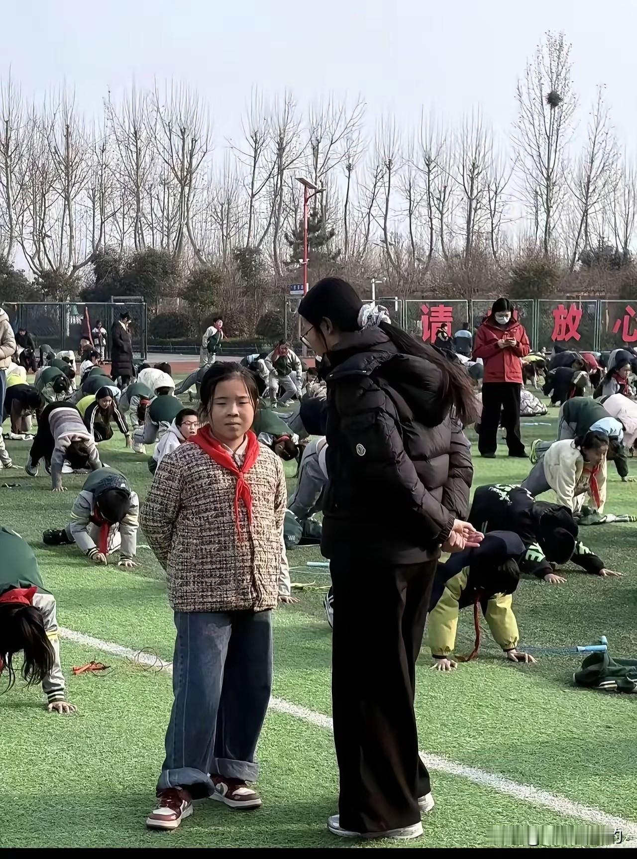 看这架势班主任很生气不过班主任为啥带个红领巾呢而且身高也不高