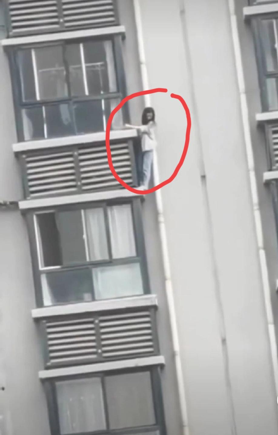 网上流出的一段视频。疑是“女版老王”被堵在人家楼上了，她就急中生智，从阳台上借助