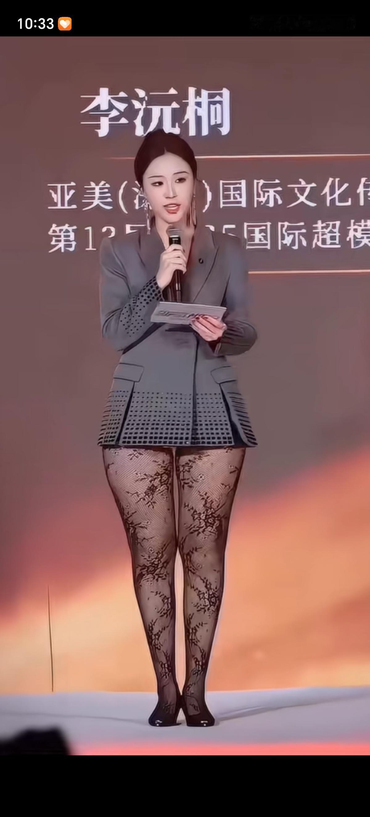被主持人的穿搭吸引了注意力，灰色西服正装搭配蕾丝花纹长腿袜，显的两条大腿像特别的