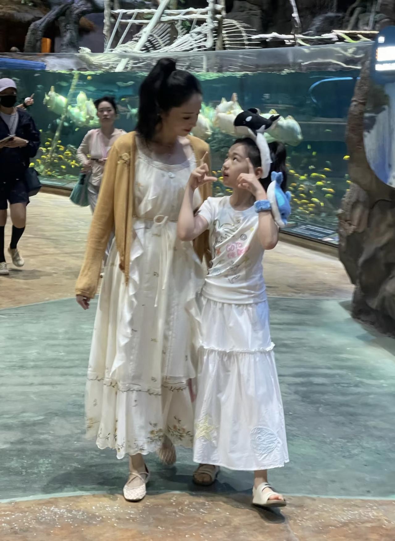 46岁董璇和10岁女儿小酒窝现身珠海长隆飞船乐园避暑，母女俩在小吃摊买薯塔，全程