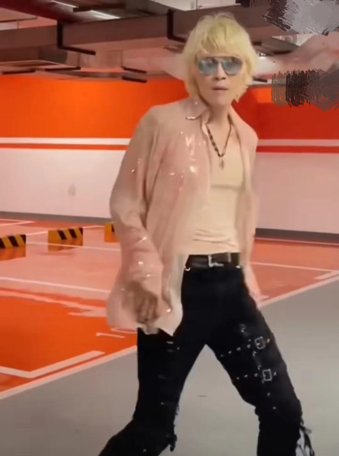 向佐真的魔怔了，在抽象的道路上越走越远。一头黄发，女款粉色透视衬衣，小背心里面还
