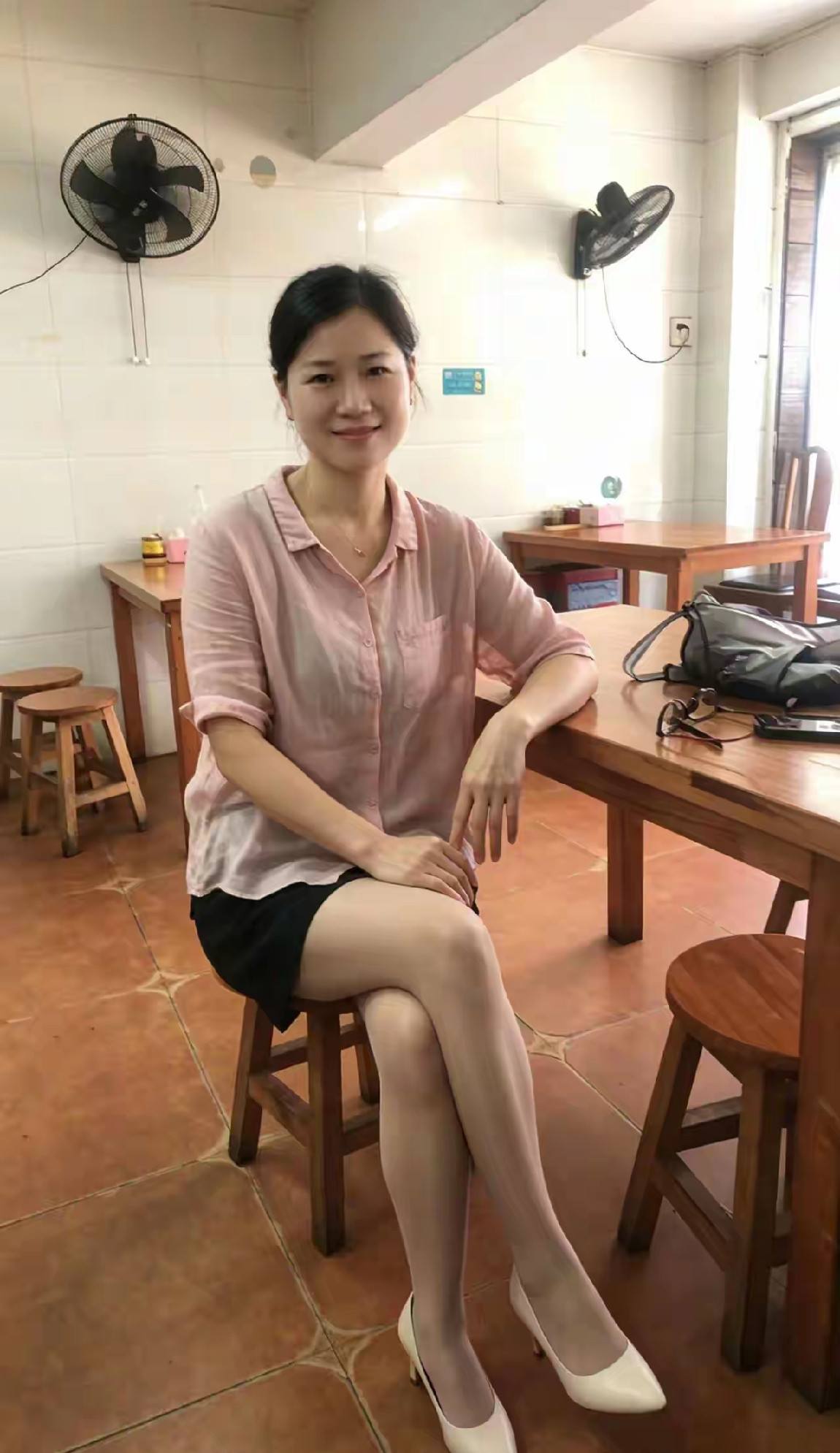 这位女士在餐馆里坐着，穿着高跟鞋。
