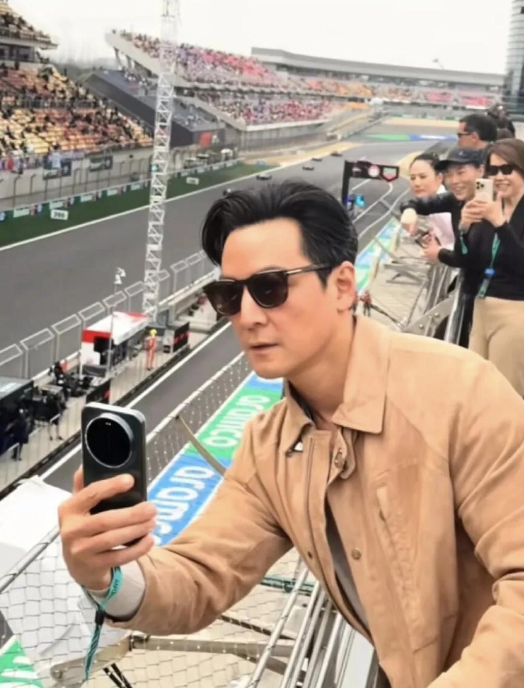 吴彦祖看F1，被后面的大妈惊艳到了。他拍赛车，人家拍他。很多明星都用苹果手机