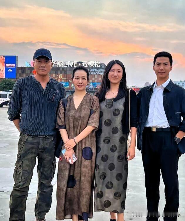 胡军一家四口的全家福合影，58岁的胡军皮肤虽然有点黑，但他是正常的大麦颜色，依旧
