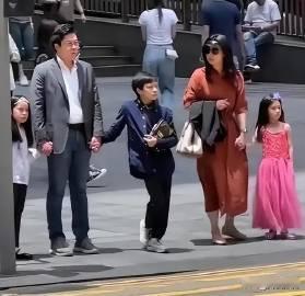 网友香港街头偶遇霍启刚一家五口逛街。郭晶晶休闲气质牵着小女儿，霍启刚父子热聊。