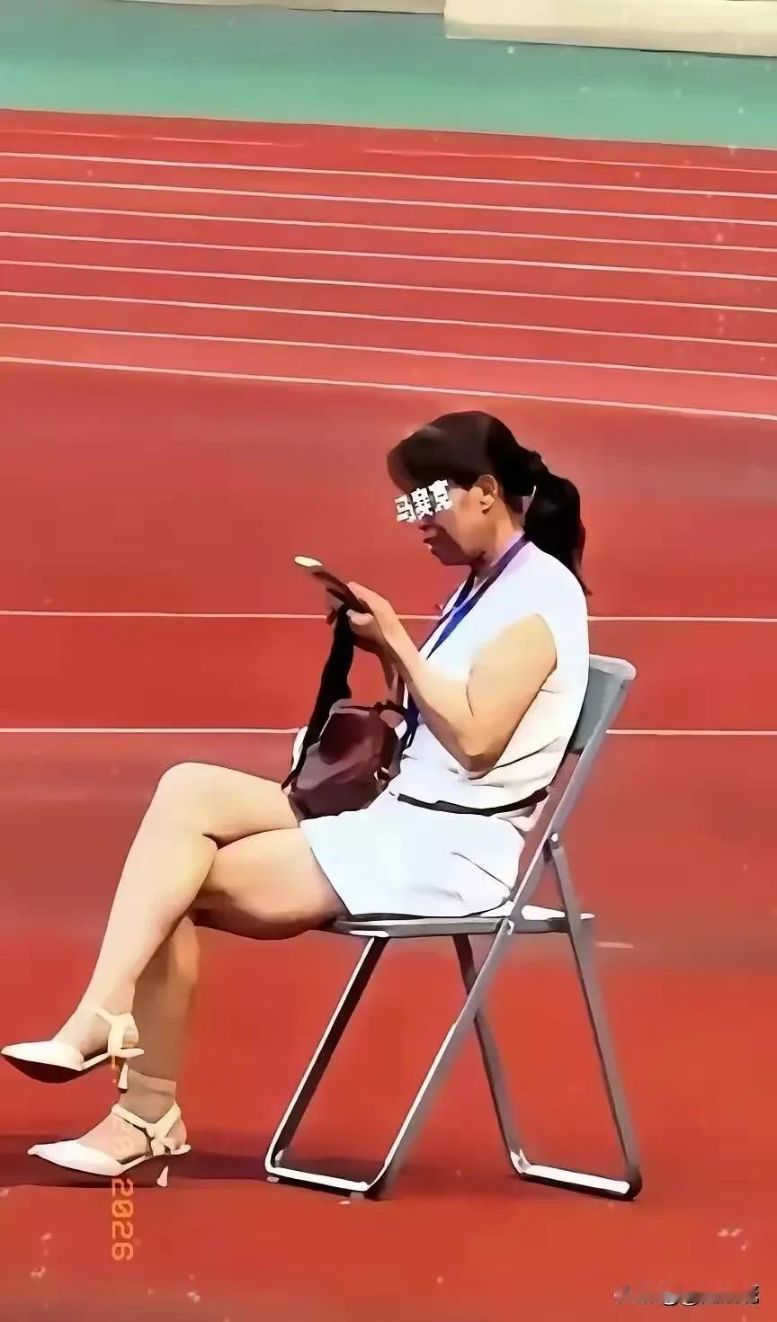 全网都在找这个甘肃陇超的女子是谁，她坐在一张椅子上，翘着二郎腿，刷着手机，脖子上
