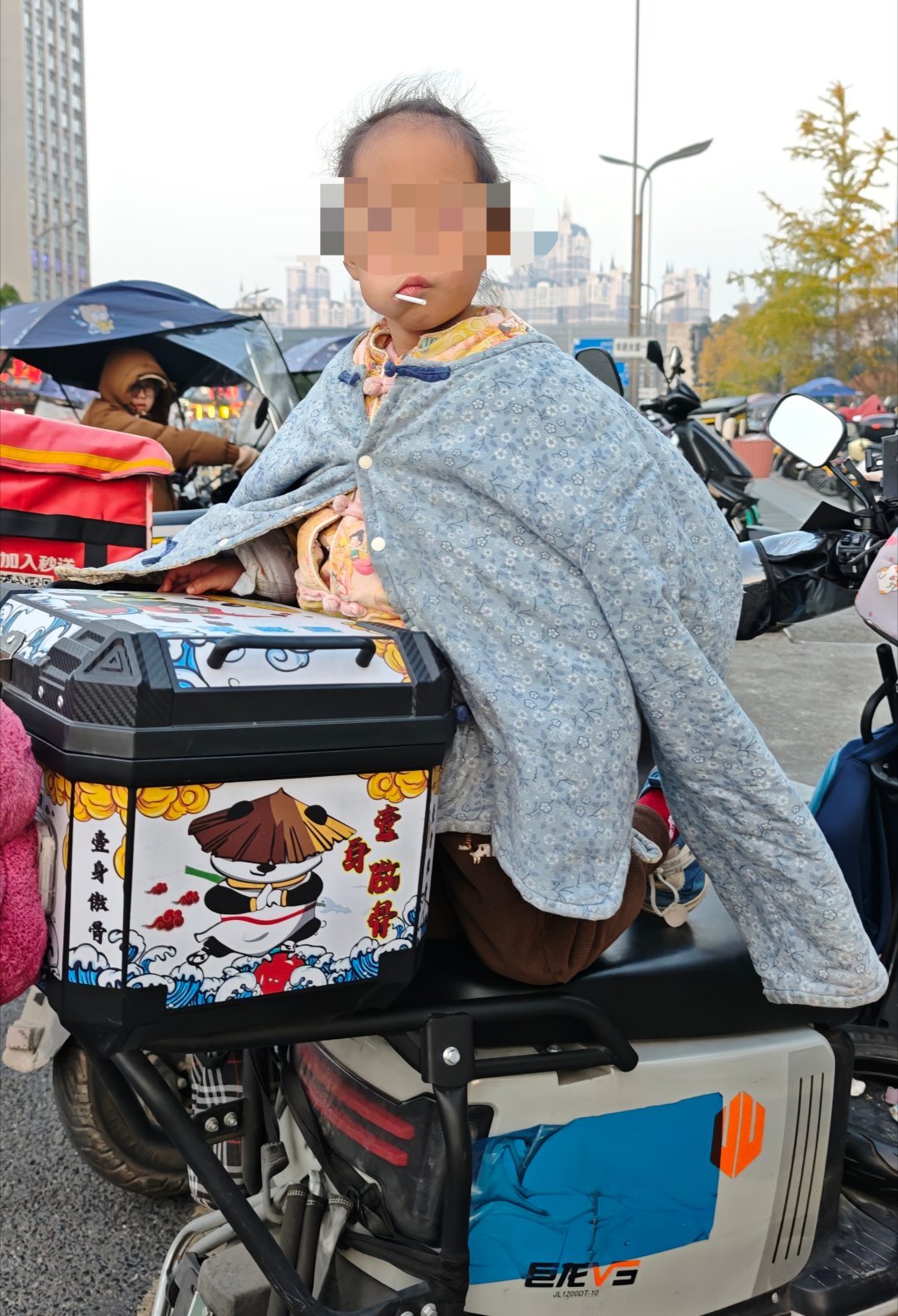 下楼看见一个小小孩，坐在外卖电动车上，天气那么冷，小孩脸被寒风吹得红红的，也没大