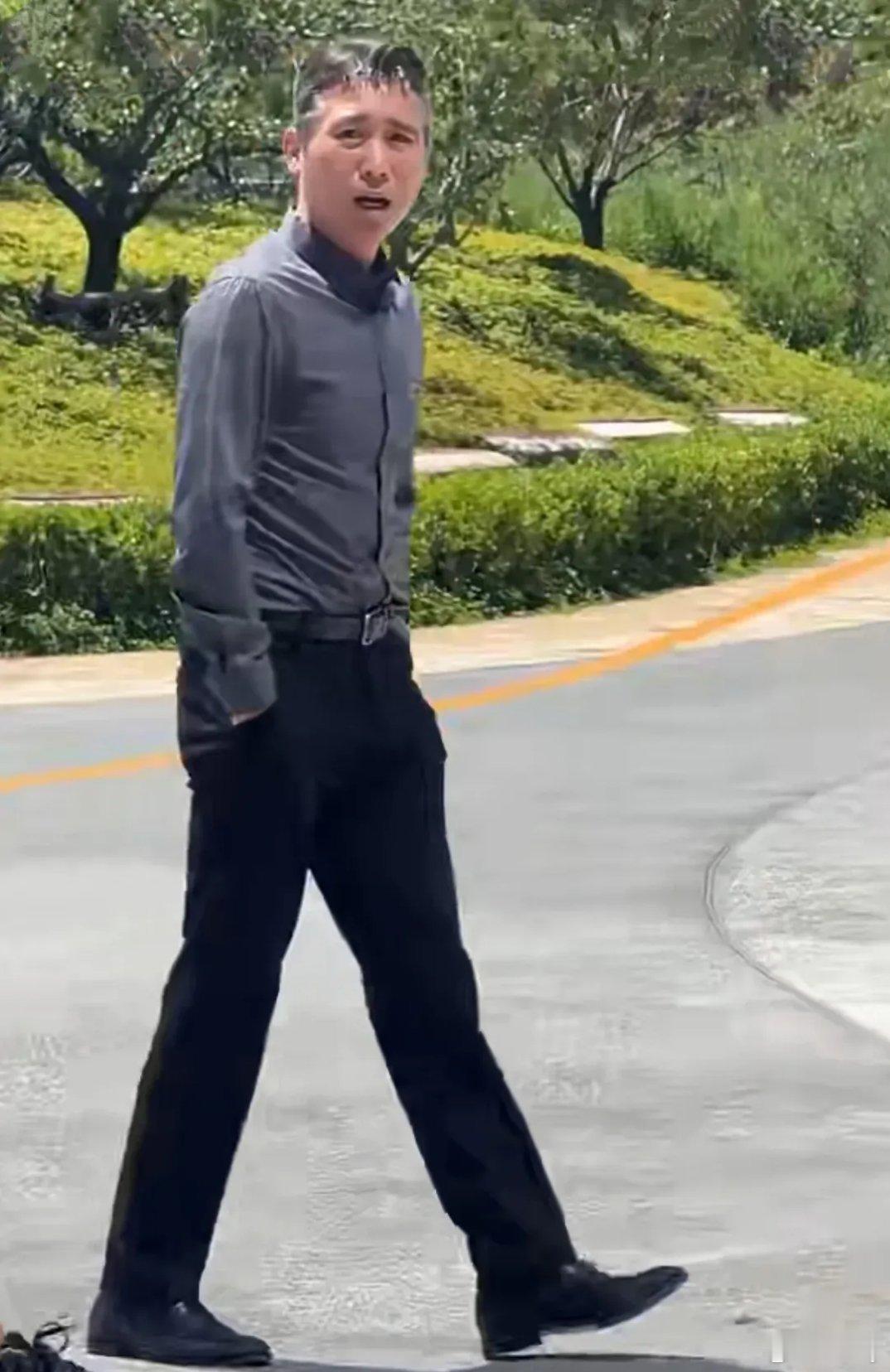型男李乃文被粉丝偶遇，一件灰色修身长袖衬衫，黑色长裤，搭配黑色正装皮鞋，李乃文显