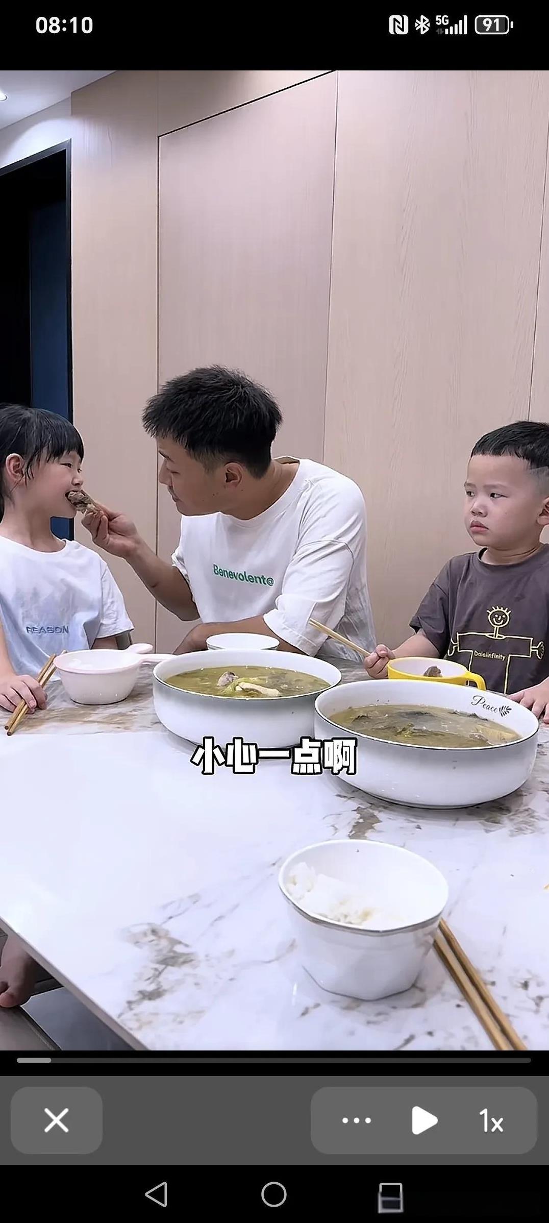 今天又把老二得罪了......爸爸夹起菜吹吹给女儿喂:“有点烫哦，小心点啊。”