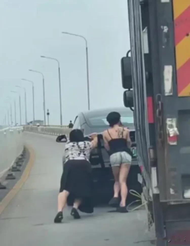 特斯拉没电了，女车主努力推车，没有任何怨言。