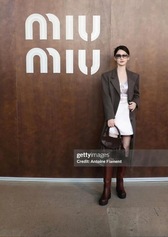 李沁巴黎MiuMiu秀场穿搭介绍，这套造型以深灰调长款西装大衣作为外搭，利落的o